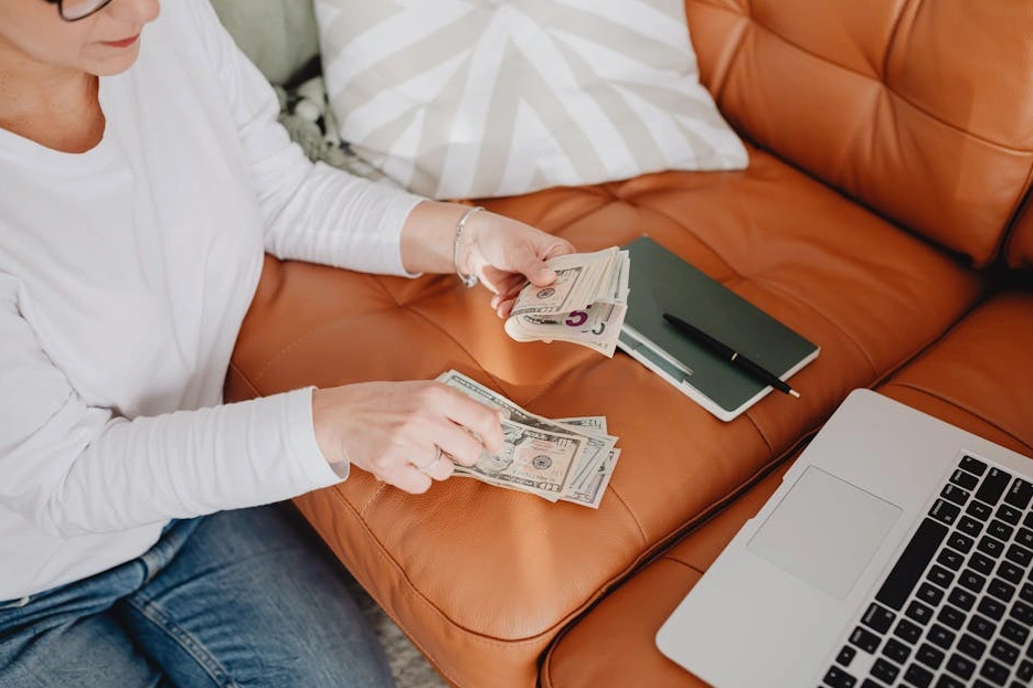 Dizüstü bilgisayarında bütçe planlaması yapan gülümseyen bir kadın